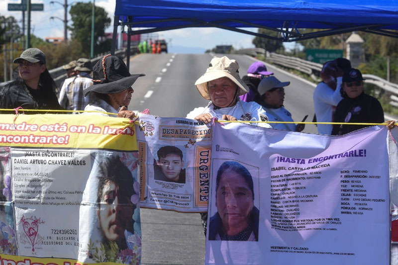 Familiares de desaparecidos exhiben fichas de búsqueda y fotografías para exigir avances en las investigaciones.
