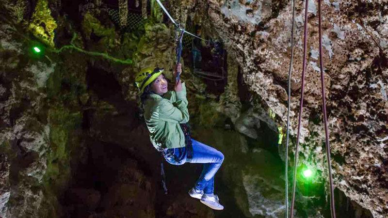 Tirolesa subterránea entre las paredes de roca de las Grutas de Xoxafi.